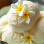 A scoop of homemade sampaguita ice cream garnished with fresh flowers